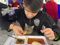 Polis yemeğini kucağına aldığı kedi ile paylaştı